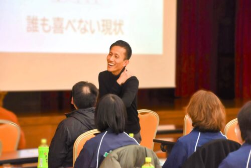 研修中に講師が参加者へマイクを向け、意見を引き出している様子